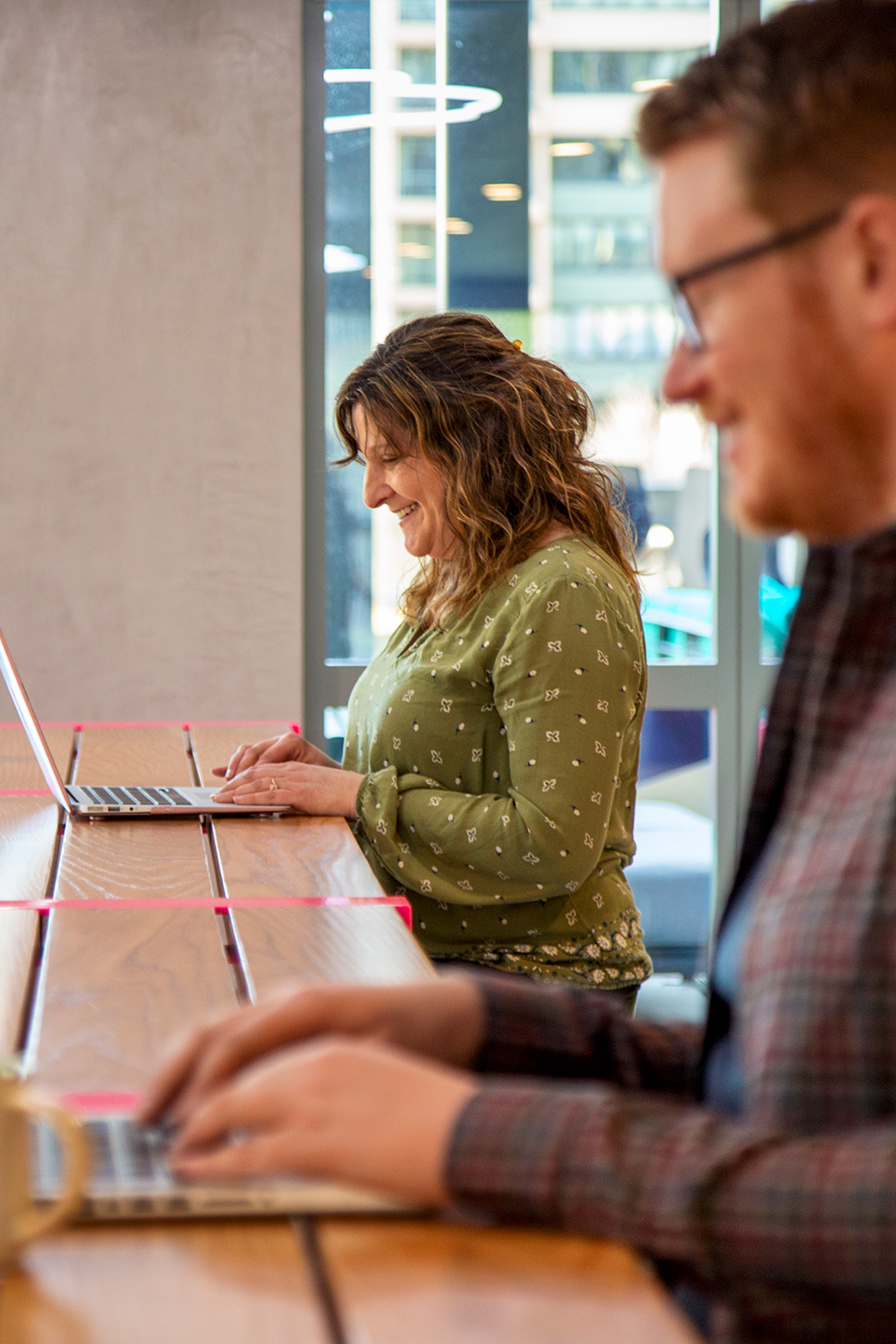 Two people typing on laptops