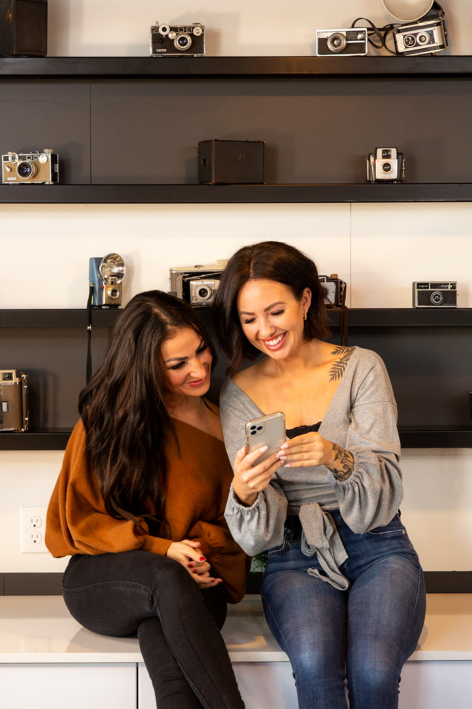 Two friends smiling at a smartphone